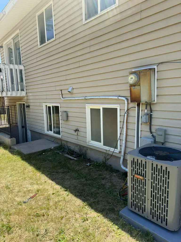 Two-story Magna home with a new RunTru air conditioner installed at the foundation
