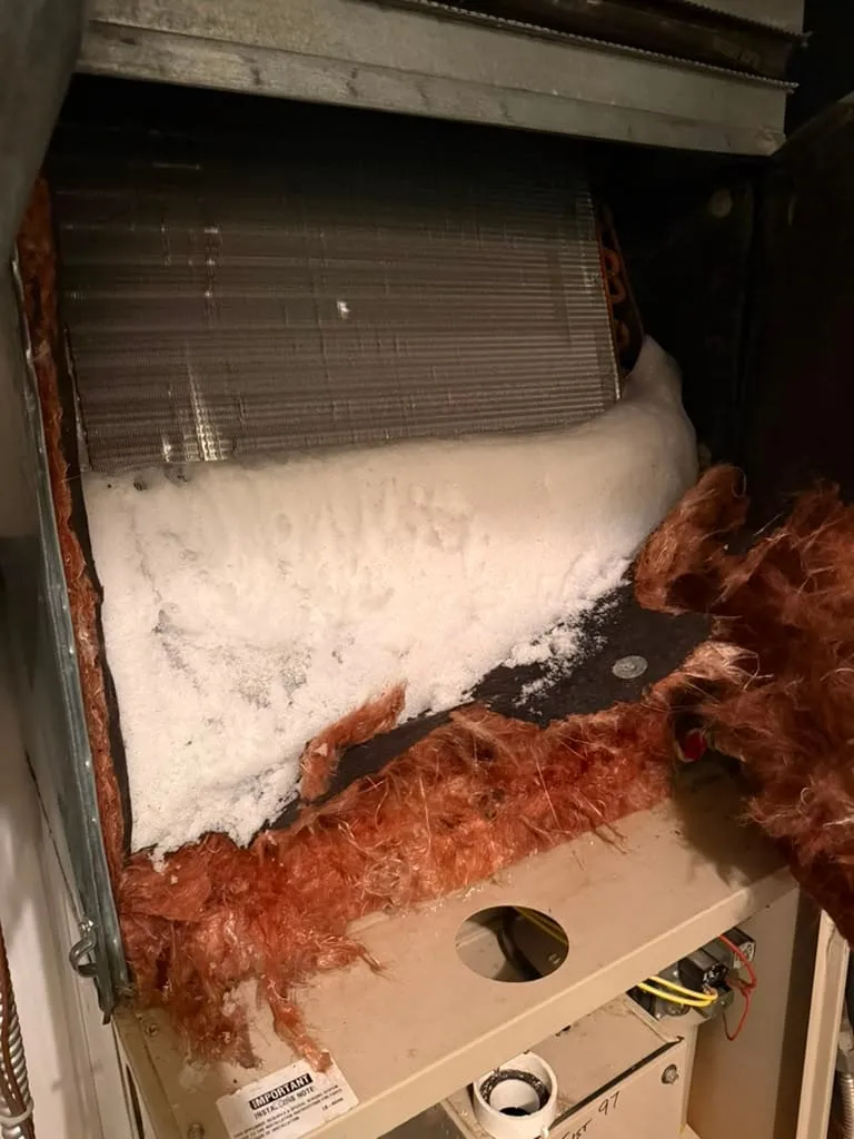 Evaporator coil encased in ice, found by Lucas Heating and Air on a service call in Magna