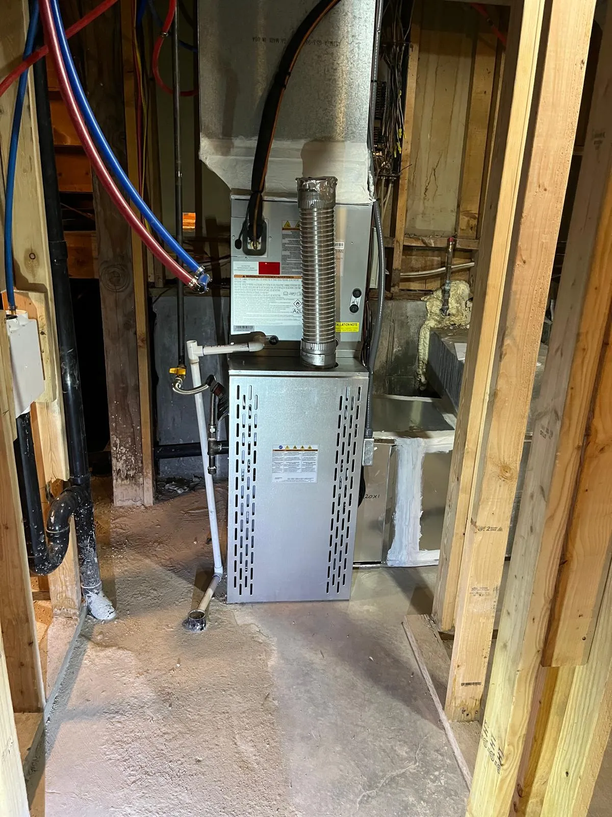 Furnace installed in a framed mechanical space during a Salt Lake City remodel, with wrapped plenum and spray foam insulation