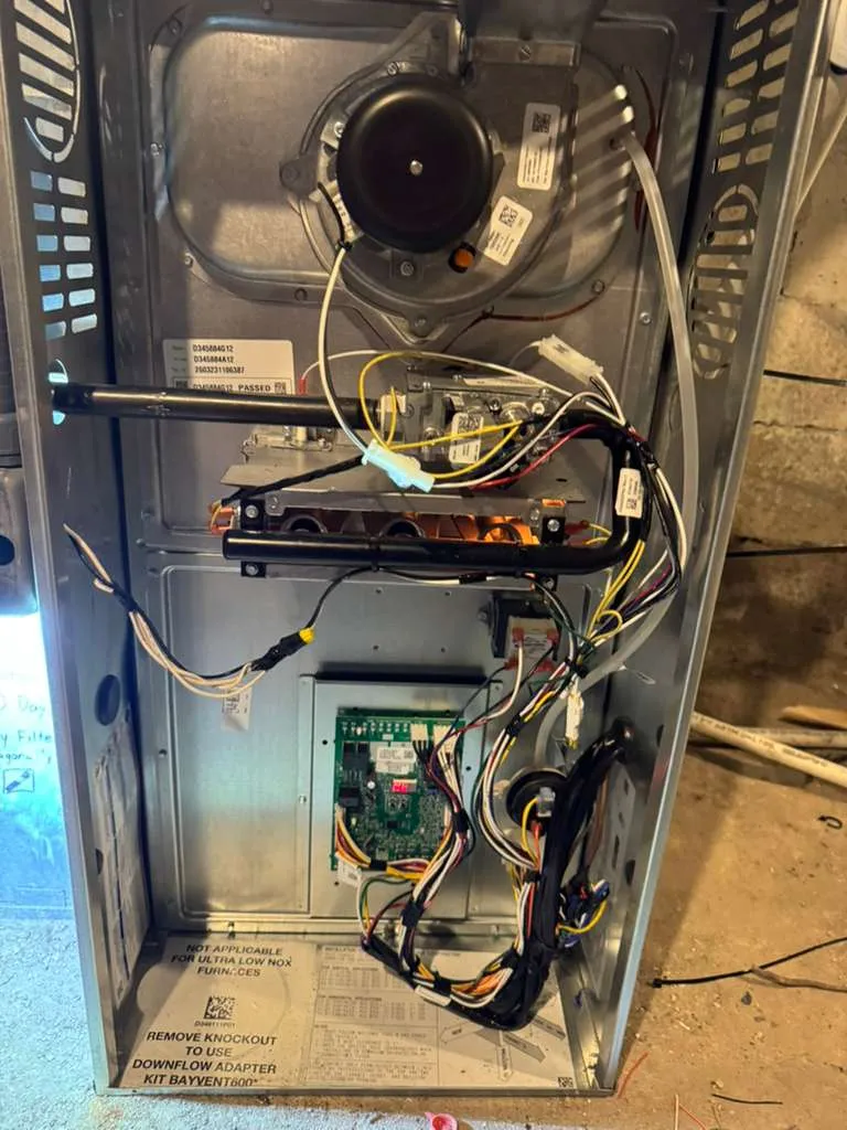 Lucas Heating and Air furnace service with the panel open, burners and control board visible
