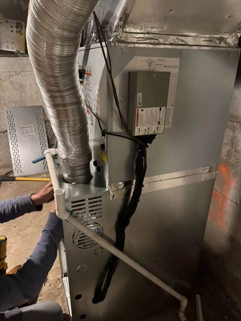 Lucas Heating and Air installer fitting PVC venting on a new furnace during a Salt Lake City remodel