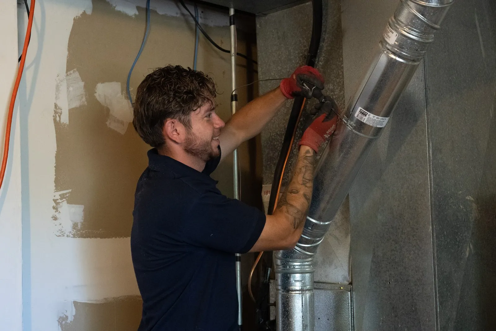 Lucas Heating and Air technician connecting a furnace flue pipe